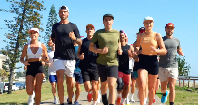 A group of people running along the beachfront